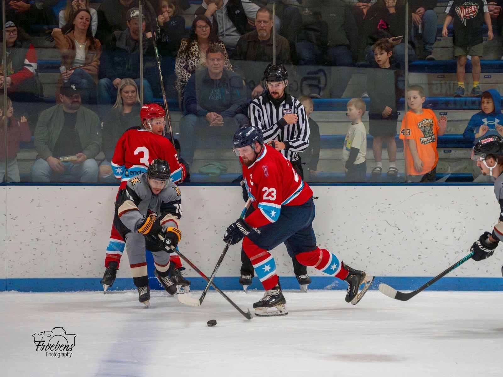 Misfits battling for the puck in front of the glass
